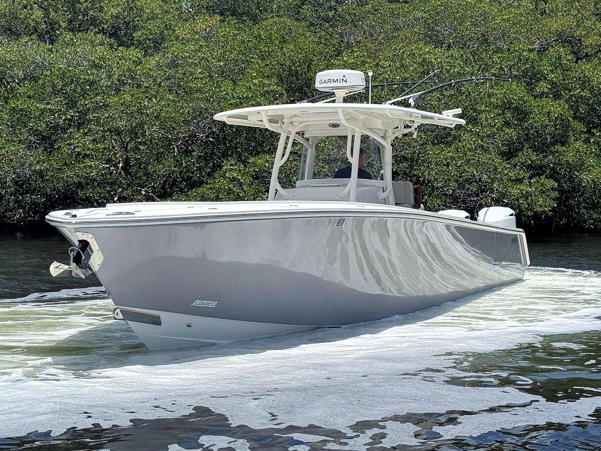 Jupiter 38 HFS 2020 Jupiter 38 HFS boat cruising on water, surrounded by lush greenery.