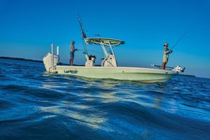 Mako 24 APEX 2026 Mako 24 APEX boat with two people fishing on a calm sea.