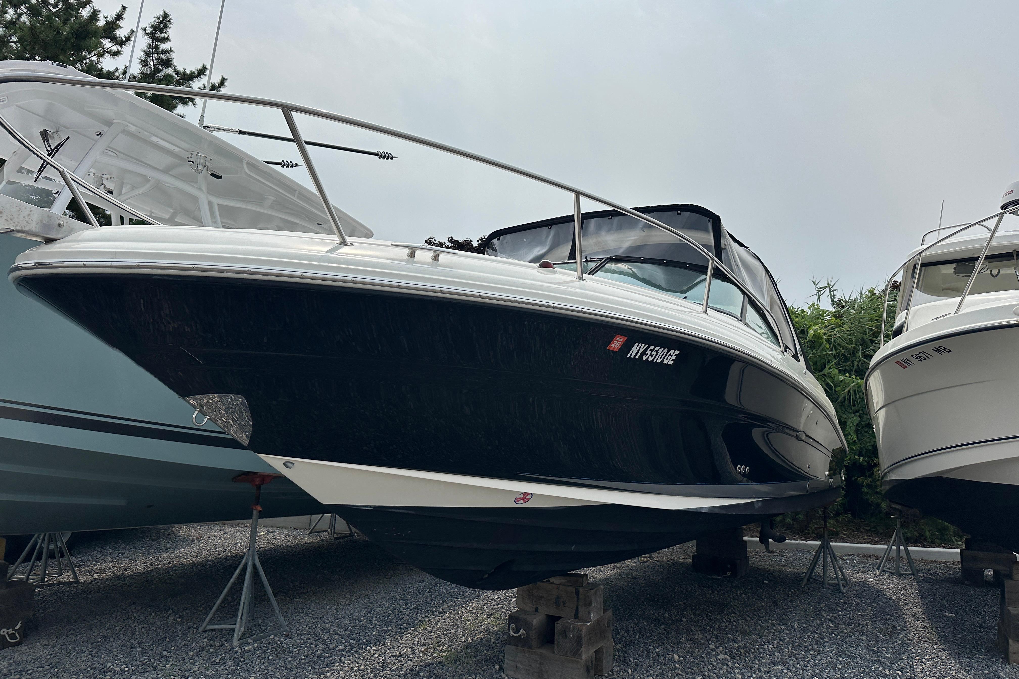 Sea Ray 290 SLX 2005 Sea Ray 290 SLX boat on stands, black hull, parked outdoors.