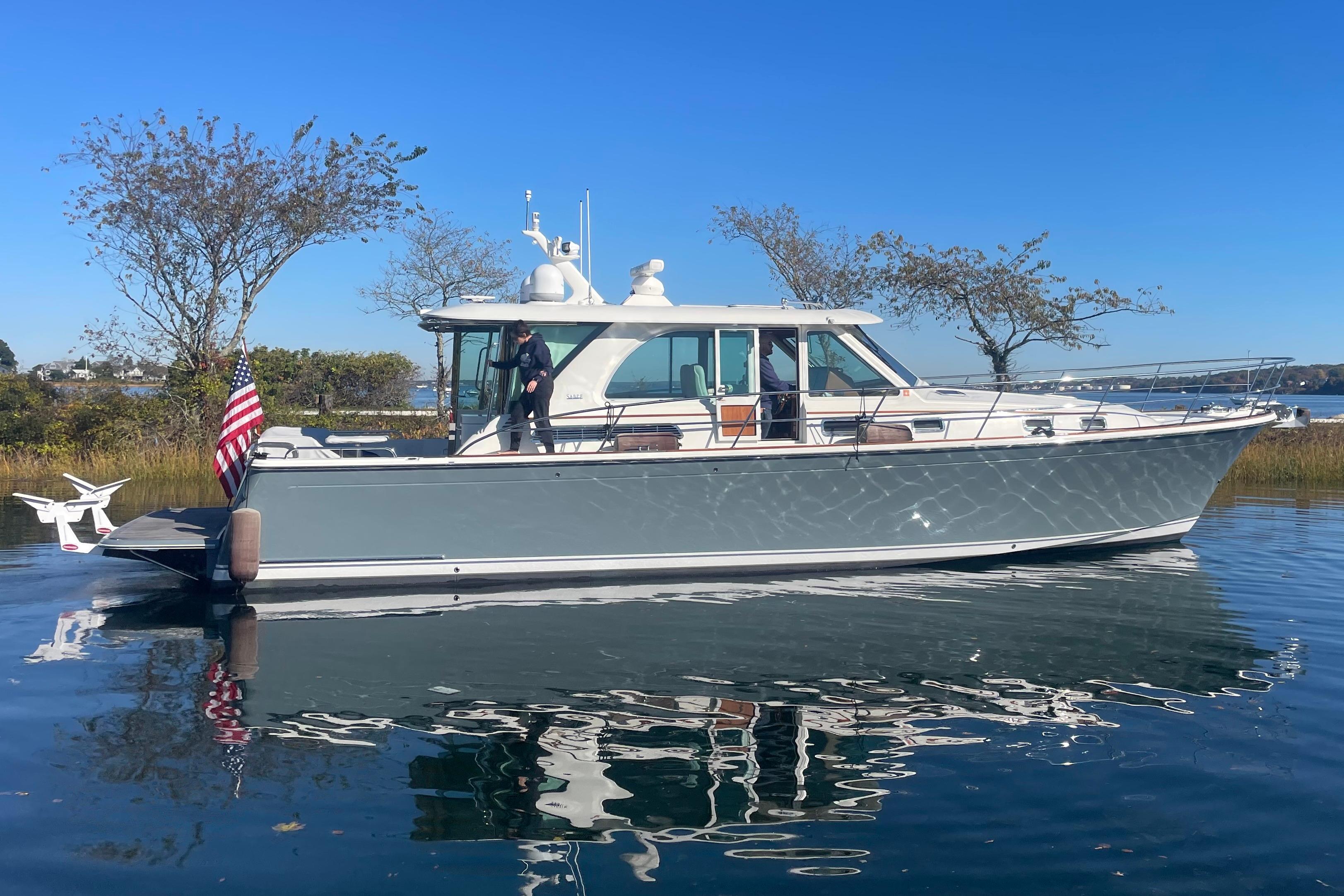 Sabre 45 Salon Express 2018 Sabre 45 Salon Express yacht on calm water, with American flag and clear blue sky.