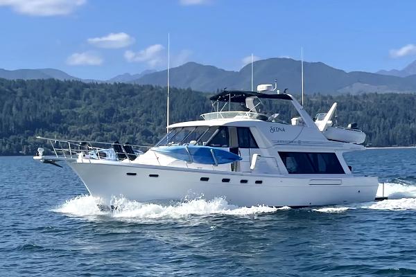 Bayliner 4788 Pilothouse 1996 Bayliner 4788 Pilothouse yacht cruising on a scenic lake with mountains in the background.