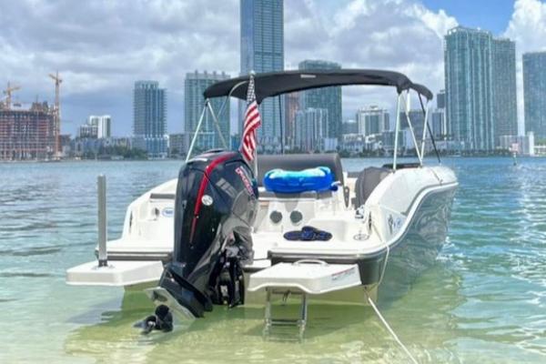 Bayliner DX2000 2022 Bayliner DX2000 boat in clear water with city skyline background.