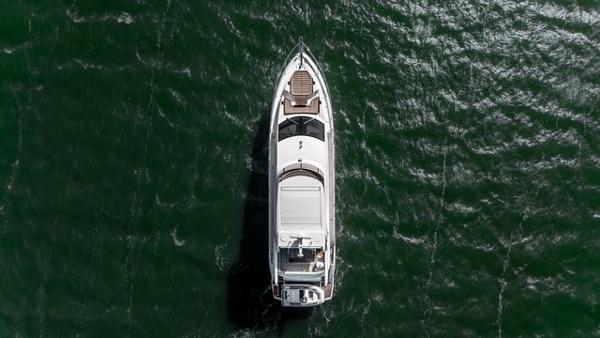 Sunseeker Manhattan 66 Aerial view of 2019 Sunseeker Manhattan 66 yacht cruising on green water.