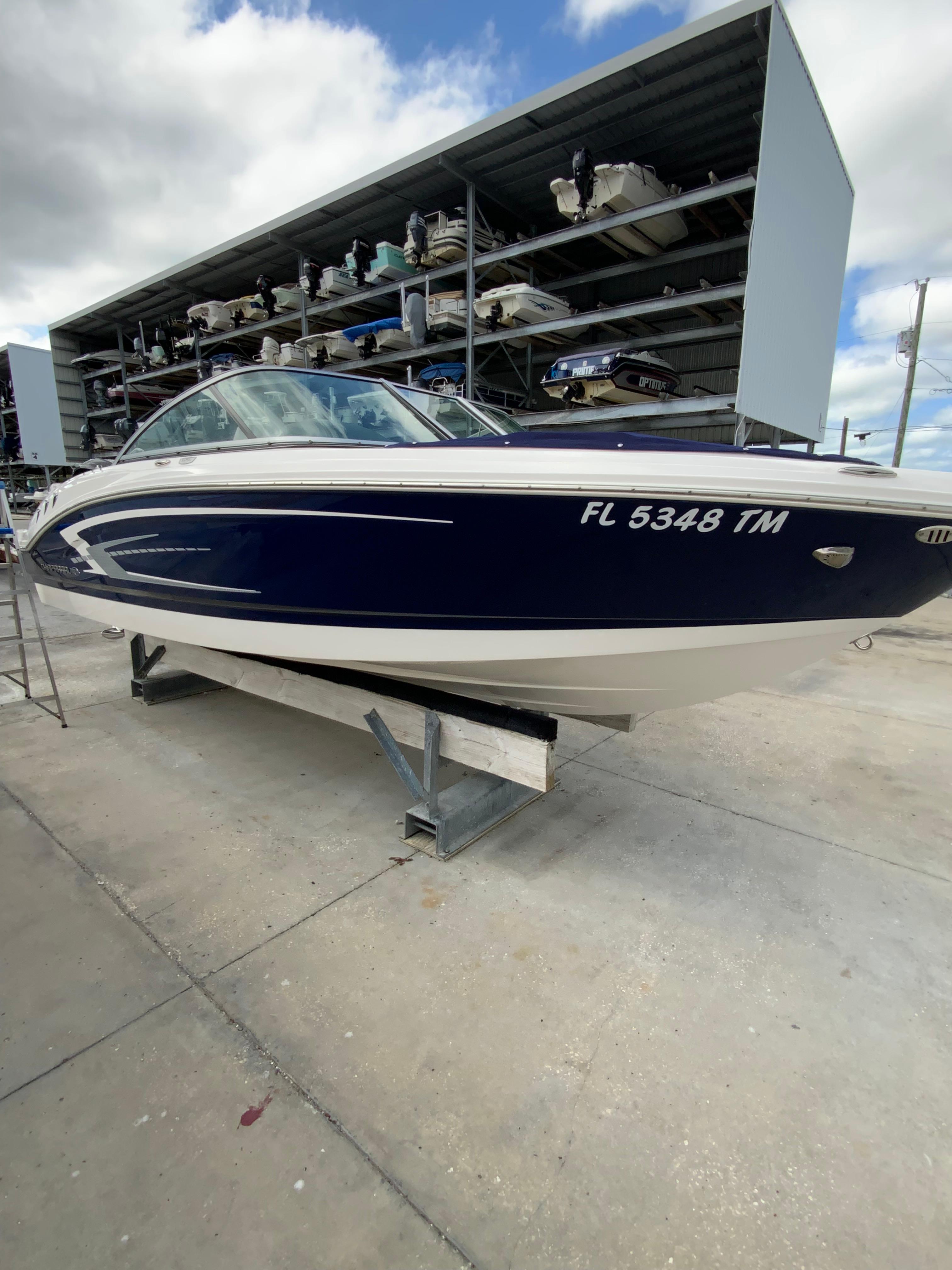 Chaparral 21 SSi 2023 Chaparral 21 SSi boat in storage, blue and white exterior, docked on a stand.
