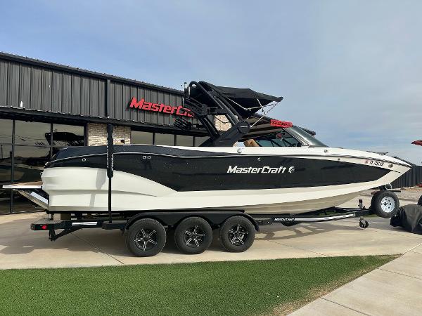 MasterCraft X26 2022 MasterCraft X26 boat on trailer outside dealership.
