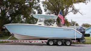 Cobia 280 Center Console 2023 Cobia 280 Center Console boat on trailer with American flag.
