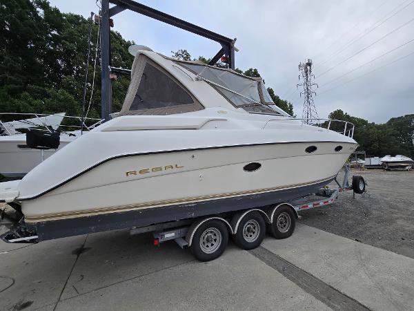 Regal 322 Commodore 1998 Regal Commodore 322 boat on a trailer, parked outdoors.