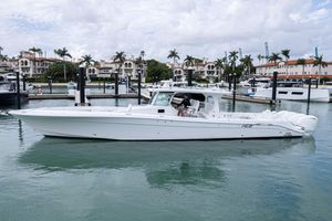 HCB 53 Sueños 2024 HCB 53 Sueños luxury boat docked in a marina with palm trees and buildings.