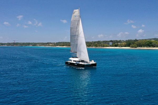 Lagoon 560 S2 Lagoon 560 S2 catamaran sailing on clear blue waters near a sandy coastline, 2015 model.