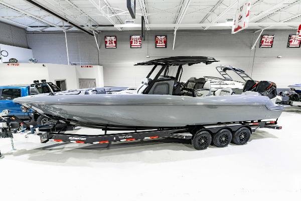 Sunsation 32 CCX 2025 Sunsation 32 CCX boat on trailer in showroom, sleek gray design.