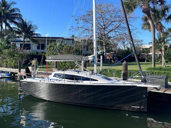 Maxus 26 2025 Maxus 26 sailboat docked by a lush, tropical waterfront.