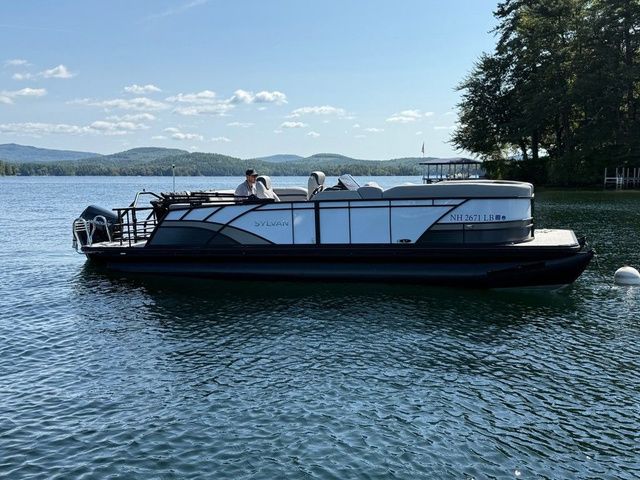 Sylvan L5 CLZ DH 2025 Sylvan L5 CLZ DH pontoon boat on a serene lake with scenic background.