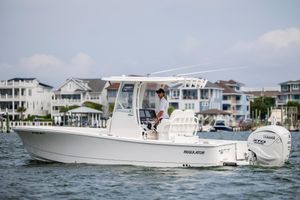 Regulator 26XO 2024 Regulator 26XO boat cruising near waterfront homes, equipped with Yamaha outboard engine.