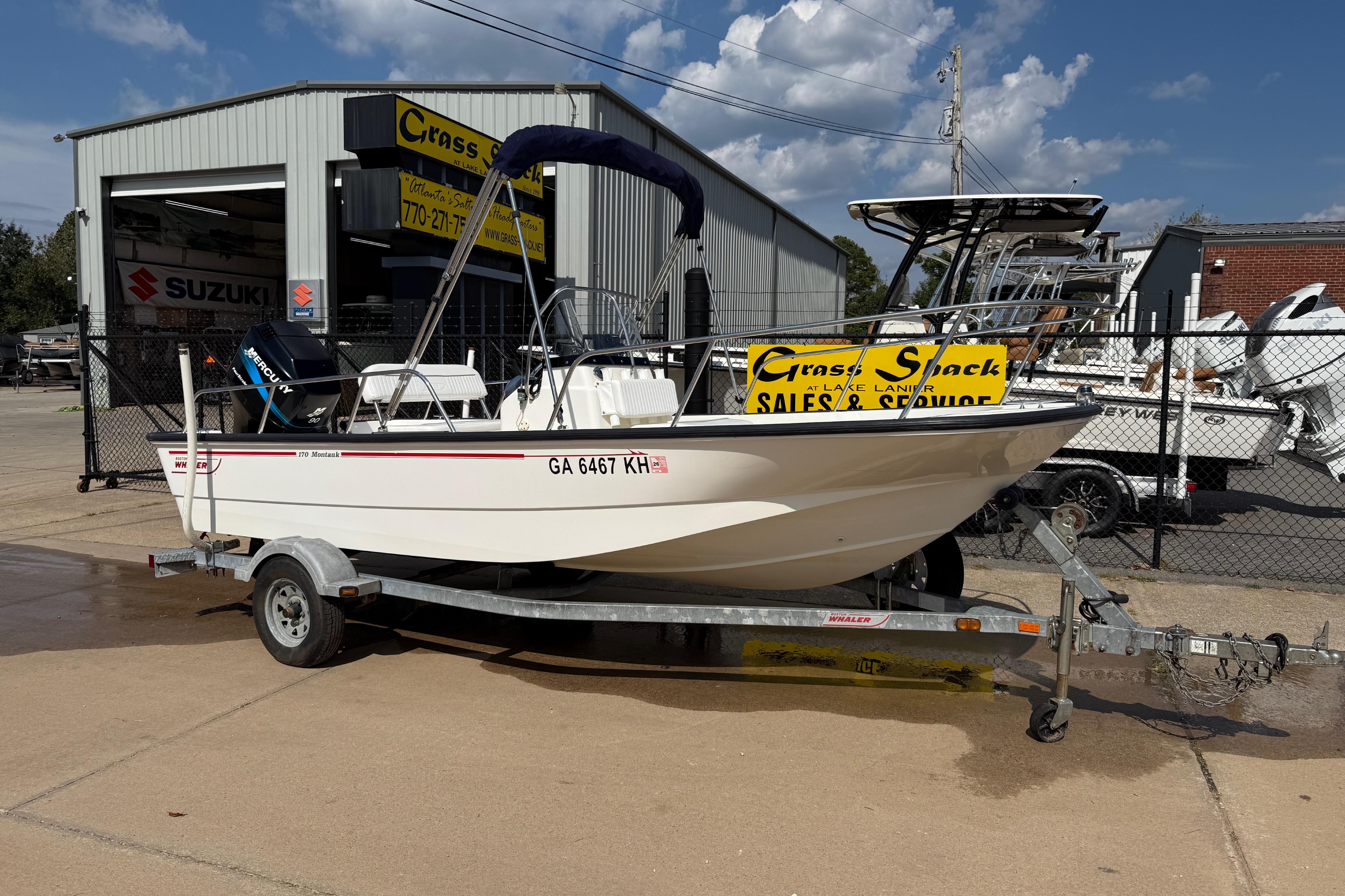 Boston Whaler 170 Montauk 2005 Boston Whaler 170 Montauk boat on trailer outside sales and service shop.