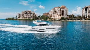 Princess S60 Princess Yachts 2018 Princess S60 yacht cruising near luxury waterfront buildings under a clear blue sky.