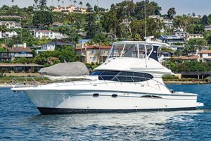 Silverton Convertible 2007 Silverton Convertible yacht cruising near a scenic coastal town.