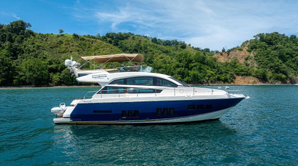 Fairline 50 2014 Fairline 50 yacht cruising on scenic blue waters near lush green coastline.
