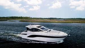 Bavaria SR41 Bavaria SR41 2022 yacht cruising on a serene waterway under a partly cloudy sky.