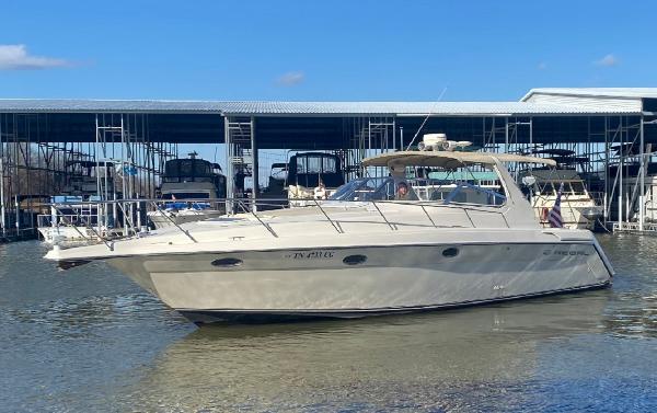 Regal 402 Regal 1999 Regal 402 boat docked at marina, calm water, clear sky.