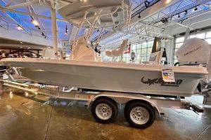 Mako 24 APEX 2026 Mako 24 APEX boat on display in a showroom with trailer.