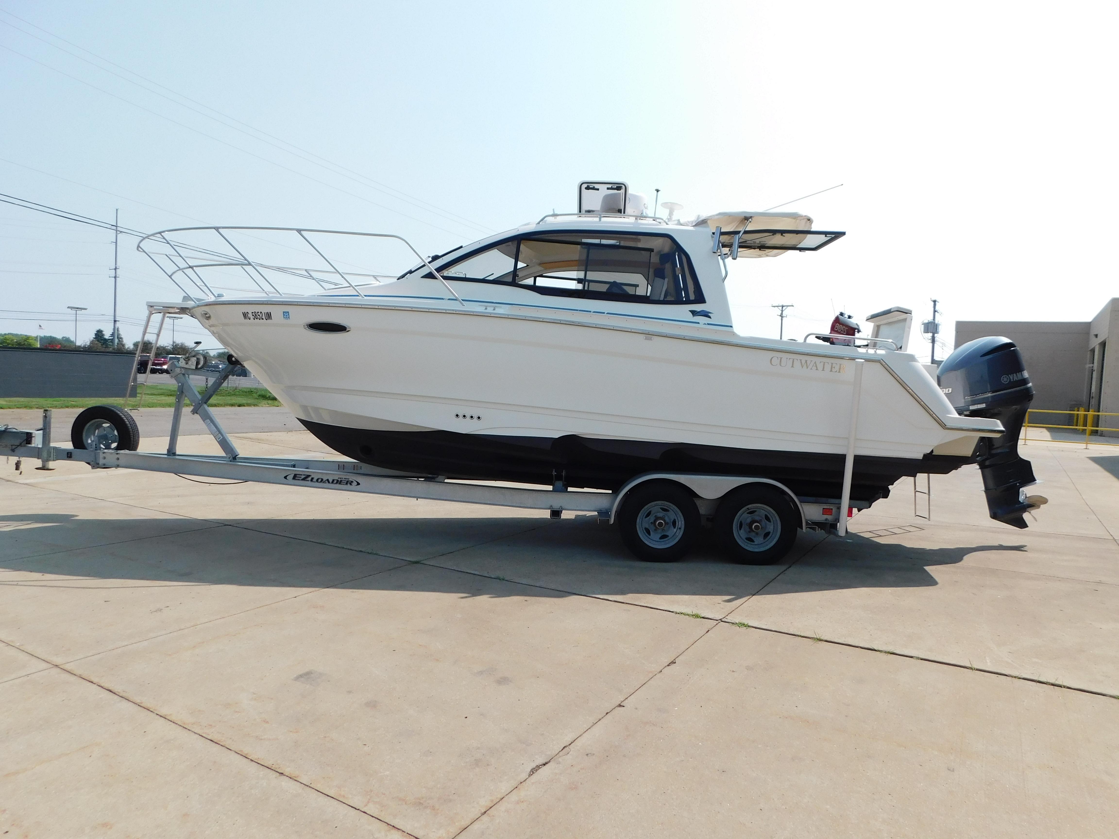 Cutwater C-24 2017 Cutwater C-24 boat on trailer, parked outdoors, side view.