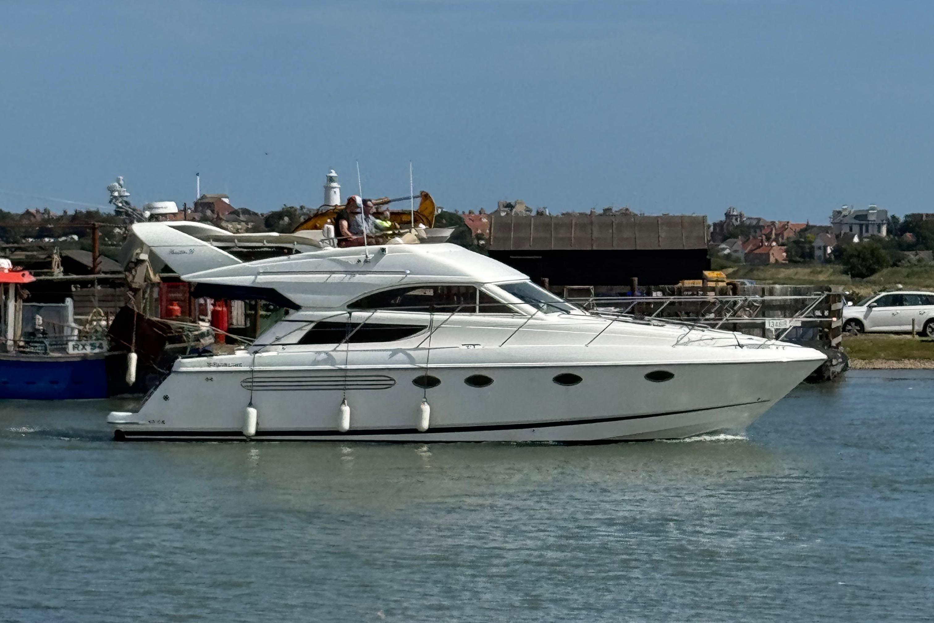 Fairline Phantom 38 2001 Fairline Phantom 38 yacht cruising in a harbor with coastal buildings in the background.