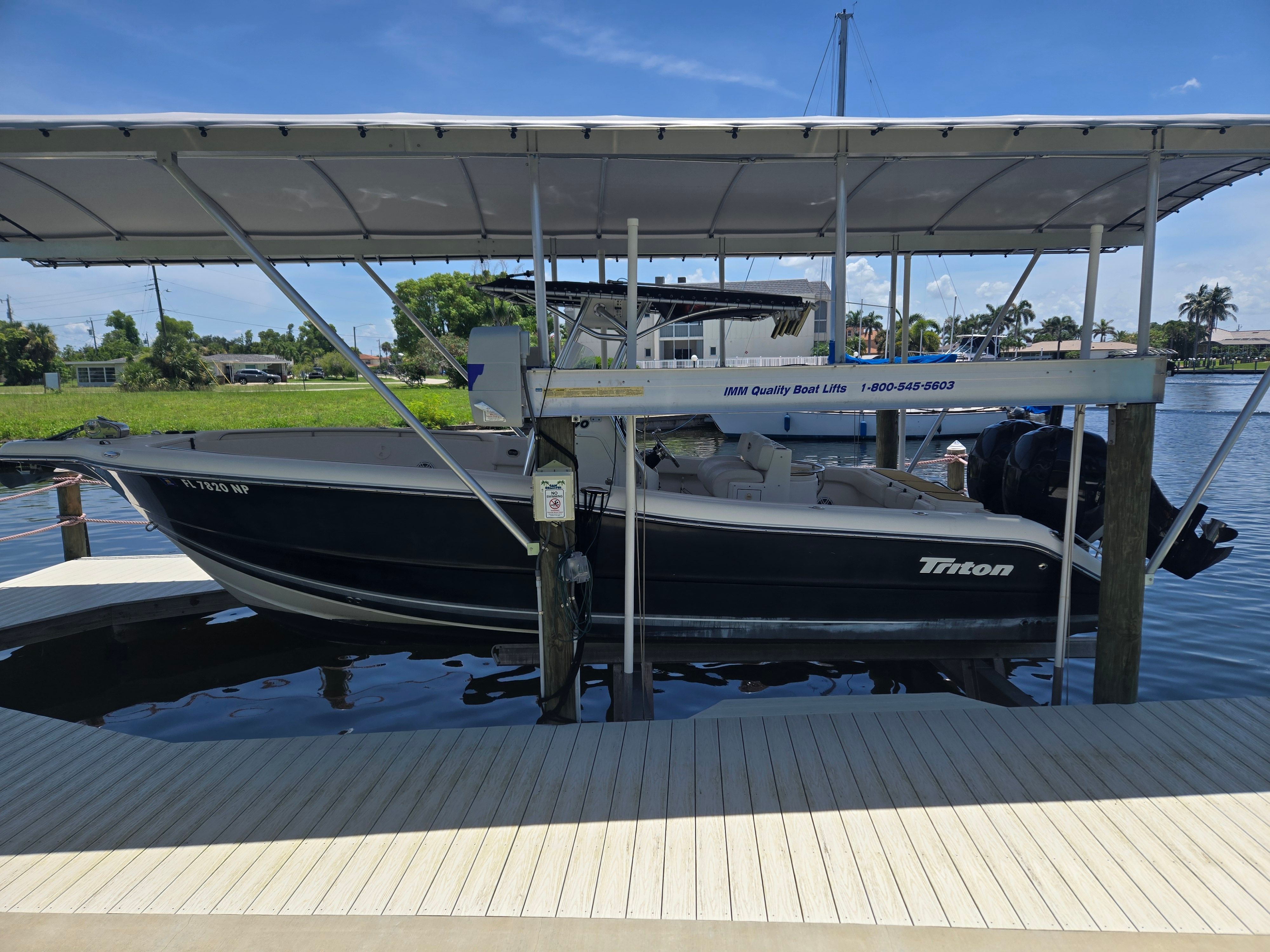 Triton 2690 CC 2007 Triton 2690 CC boat on lift, docked by a scenic waterfront.