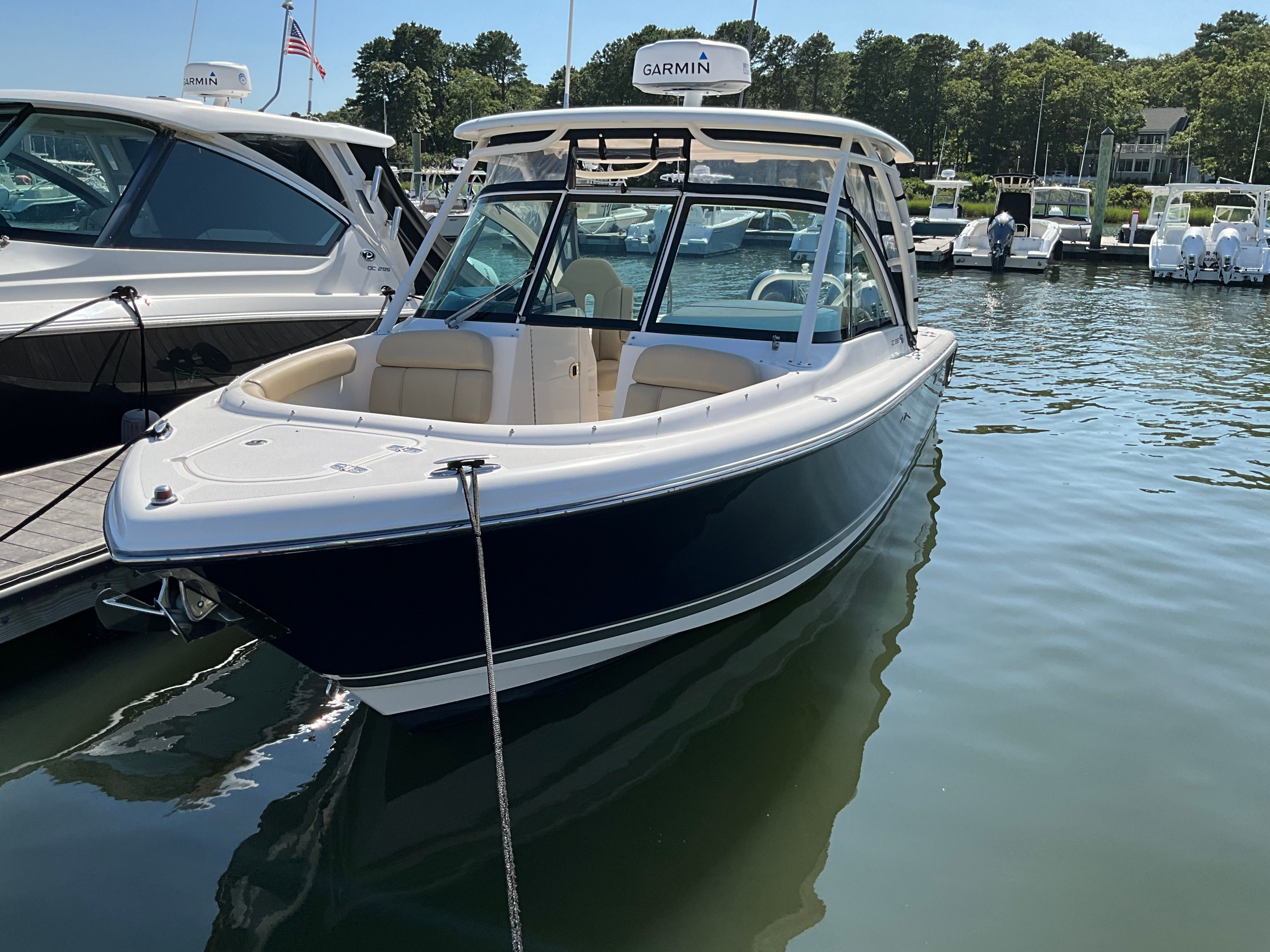 Pursuit DC 265 Dual Console 2016 Pursuit DC 265 Dual Console boat docked in a marina, featuring sleek design and Garmin equipment.