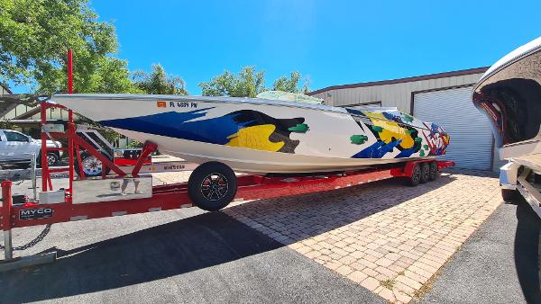 Cigarette Tiger 42 Cigarette Tiger 42 boat, 2000 model, with colorful design on a red trailer.
