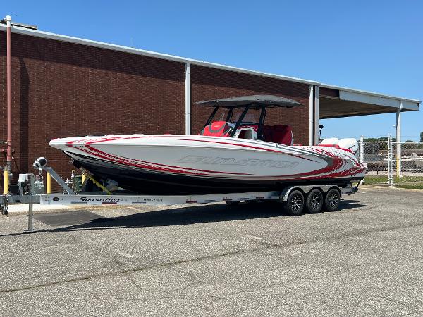 Sunsation 32 CCX 2019 Sunsation 32 CCX boat on trailer, red and white design, parked outdoors.