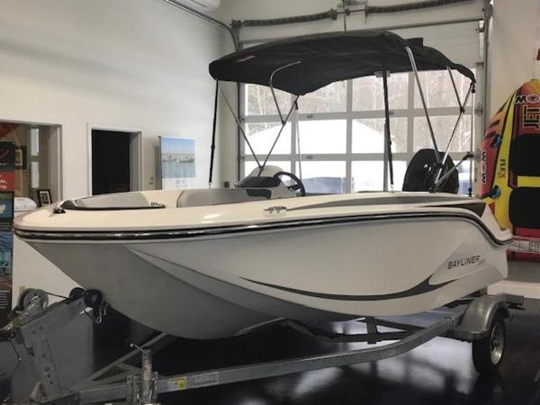 Bayliner M15 2025 Bayliner M15 boat in showroom, featuring sleek design and canopy.
