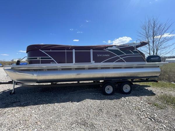 Sylvan Mirage 8524 CLZ 2024 Sylvan Mirage 8524 CLZ pontoon boat on a trailer under a clear blue sky.