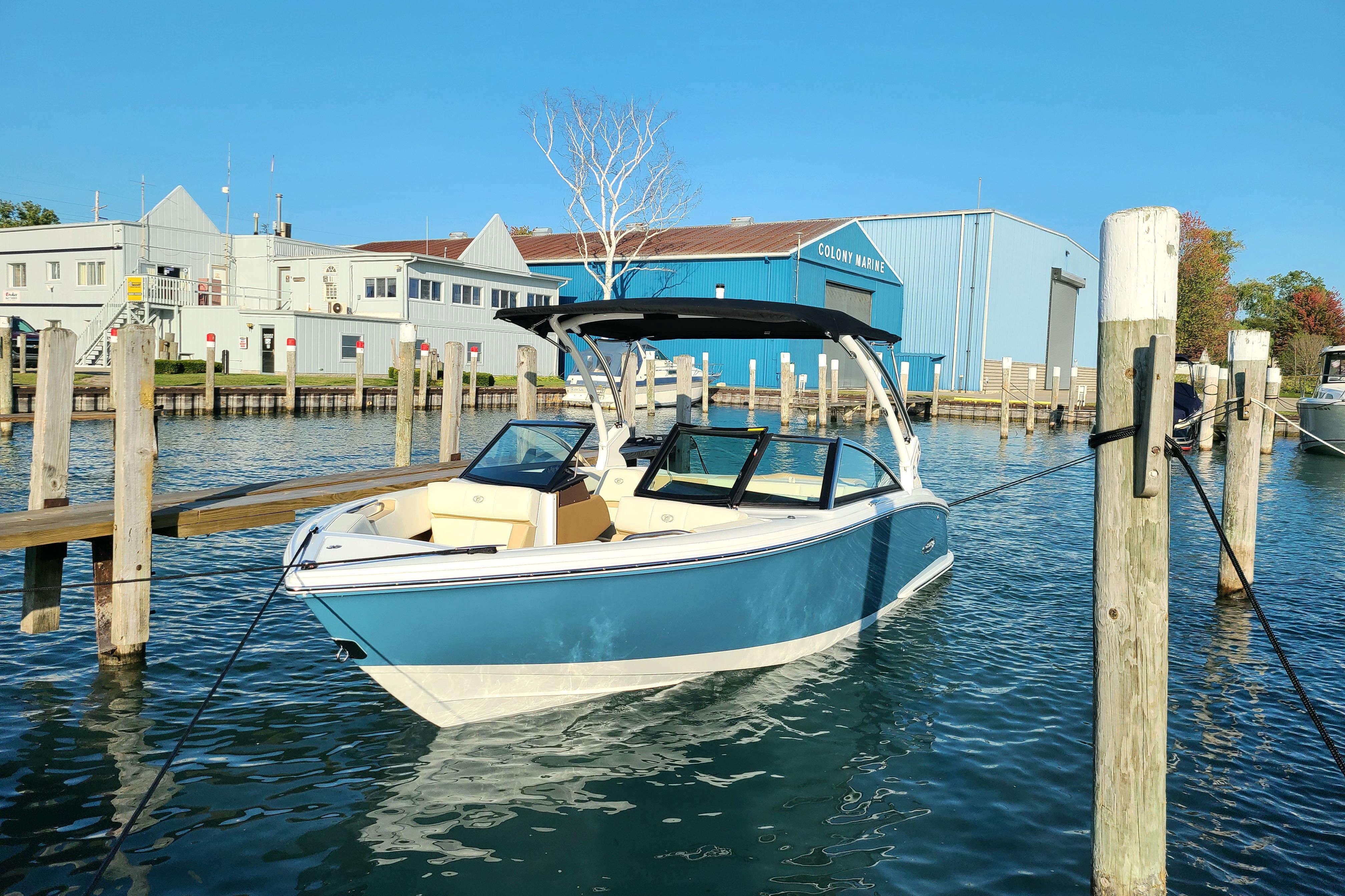 Cobalt CS22 2022 Cobalt CS22 boat docked at marina with blue building in background.