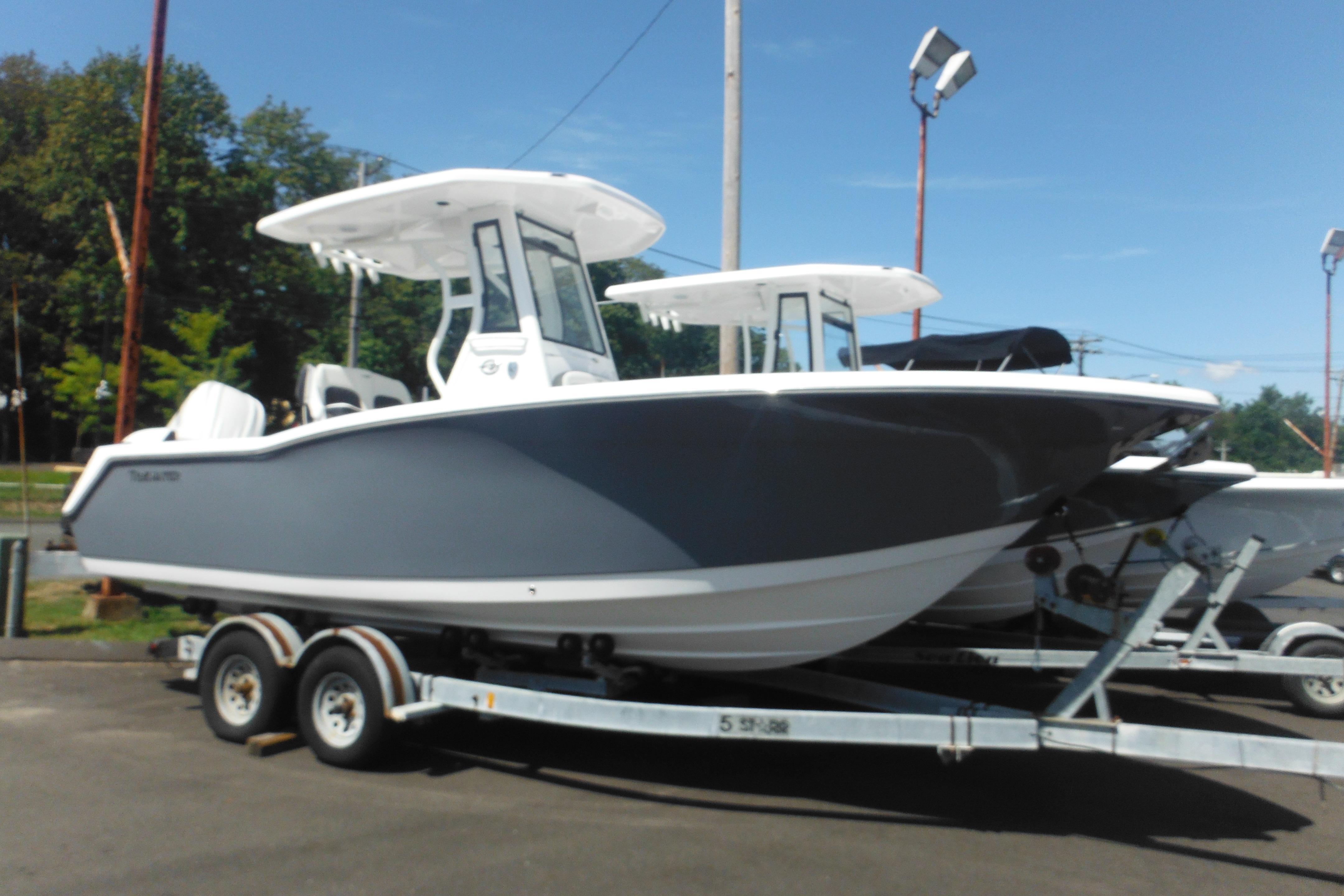 Tidewater 232 LXF 2026 Tidewater 232 LXF boat on trailer, parked outdoors under clear sky.
