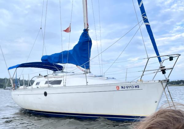Beneteau First 285 1990 Beneteau First 285 sailboat with blue sail cover on calm water.