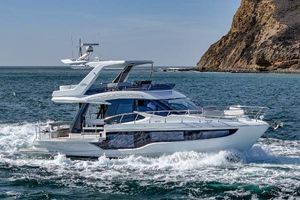 Galeon 500 Fly 2025 Galeon 500 Fly yacht cruising near rocky coastline.