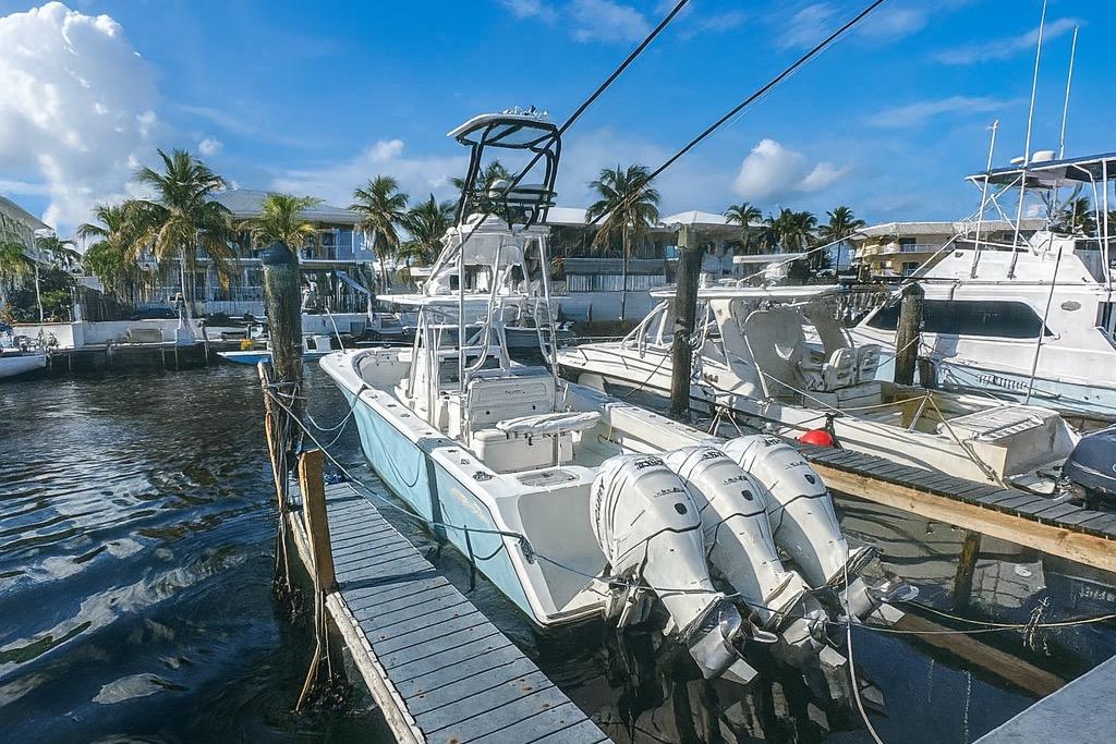 SeaHunter 39 2017 Sea Hunter 39 boat docked with triple outboard engines, surrounded by palm trees.