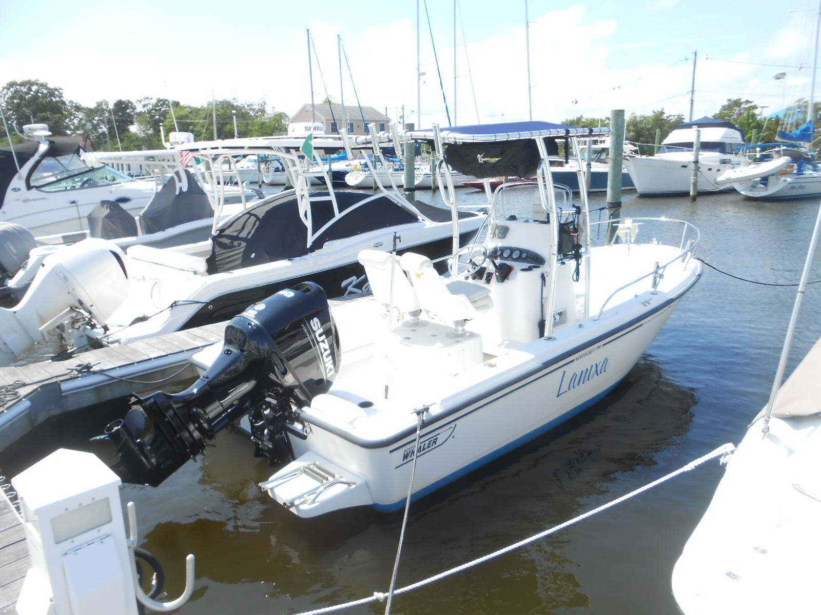 Boston Whaler 190 Nantucket 2003 Boston Whaler 190 Nantucket boat docked in marina with Suzuki outboard motor.