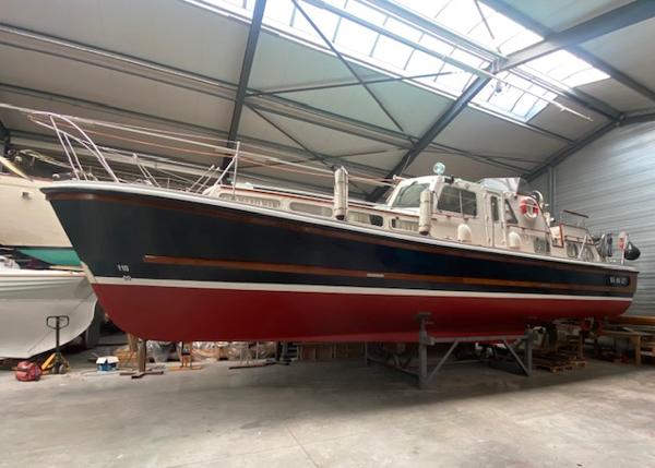 Nelson 45 1971 Nelson 45 boat with red hull in a warehouse.