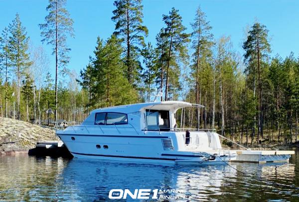 Nimbus 405 Coupé 2022 Nimbus 405 Coupé boat docked in a serene forest lake.