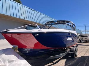 Yamaha Boats 252XE 2025 Yamaha Boats 252XE, blue and red, parked on a trailer under a clear sky.