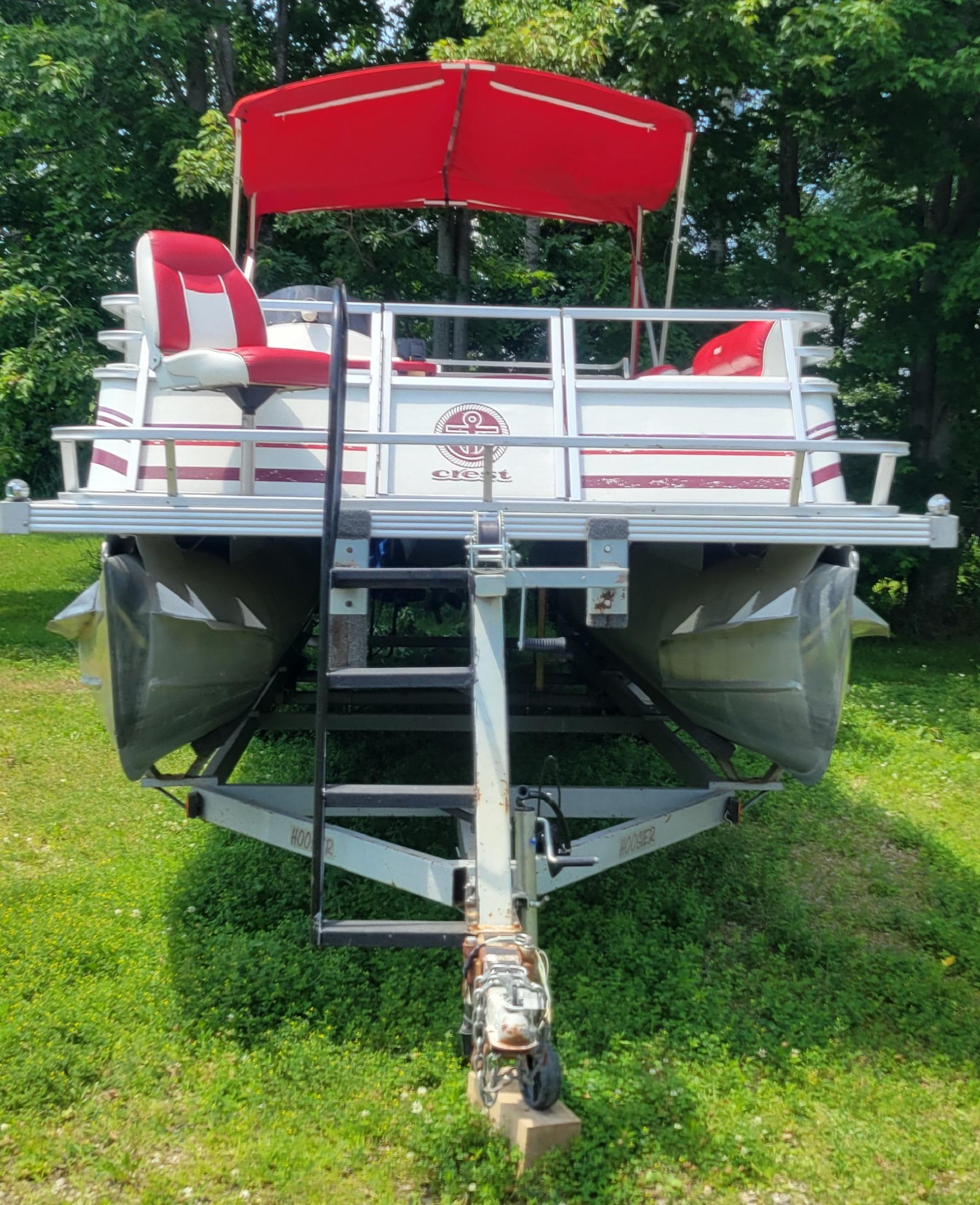 Crest Crest III 1995 Crest III pontoon boat with red canopy and seats, parked on grass.