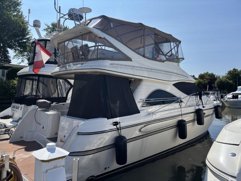 Maxum 4600 SCB 1998 Maxum 4600 SCB yacht docked, featuring a sleek design and covered upper deck.