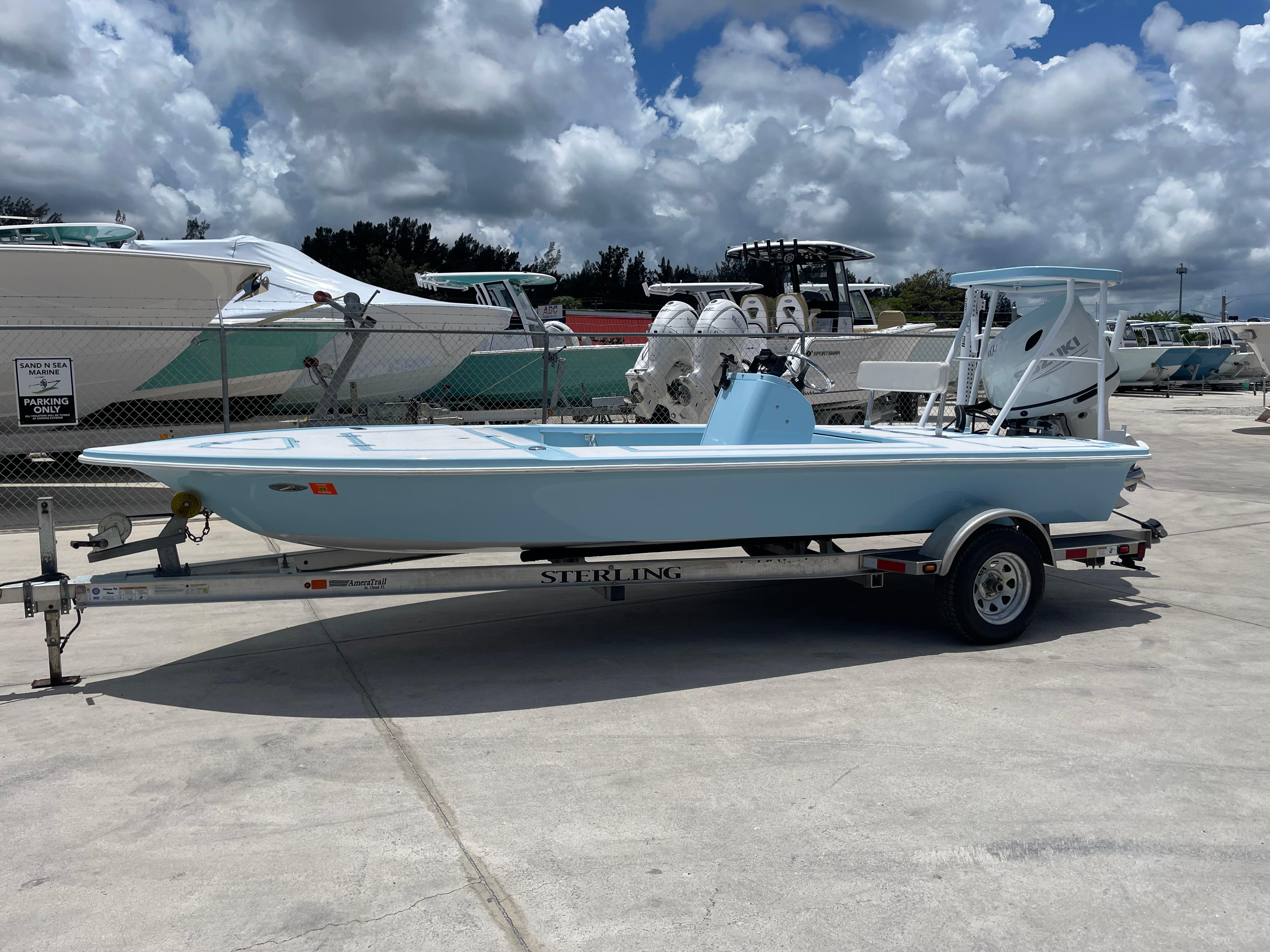 Sterling 180 TS 2005 Sterling 180 TS boat on trailer, parked at marina under cloudy sky.