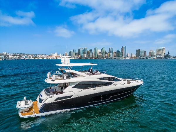 Sunseeker 75 Yacht 2014 Sunseeker 75 Yacht cruising near a city skyline on a sunny day.