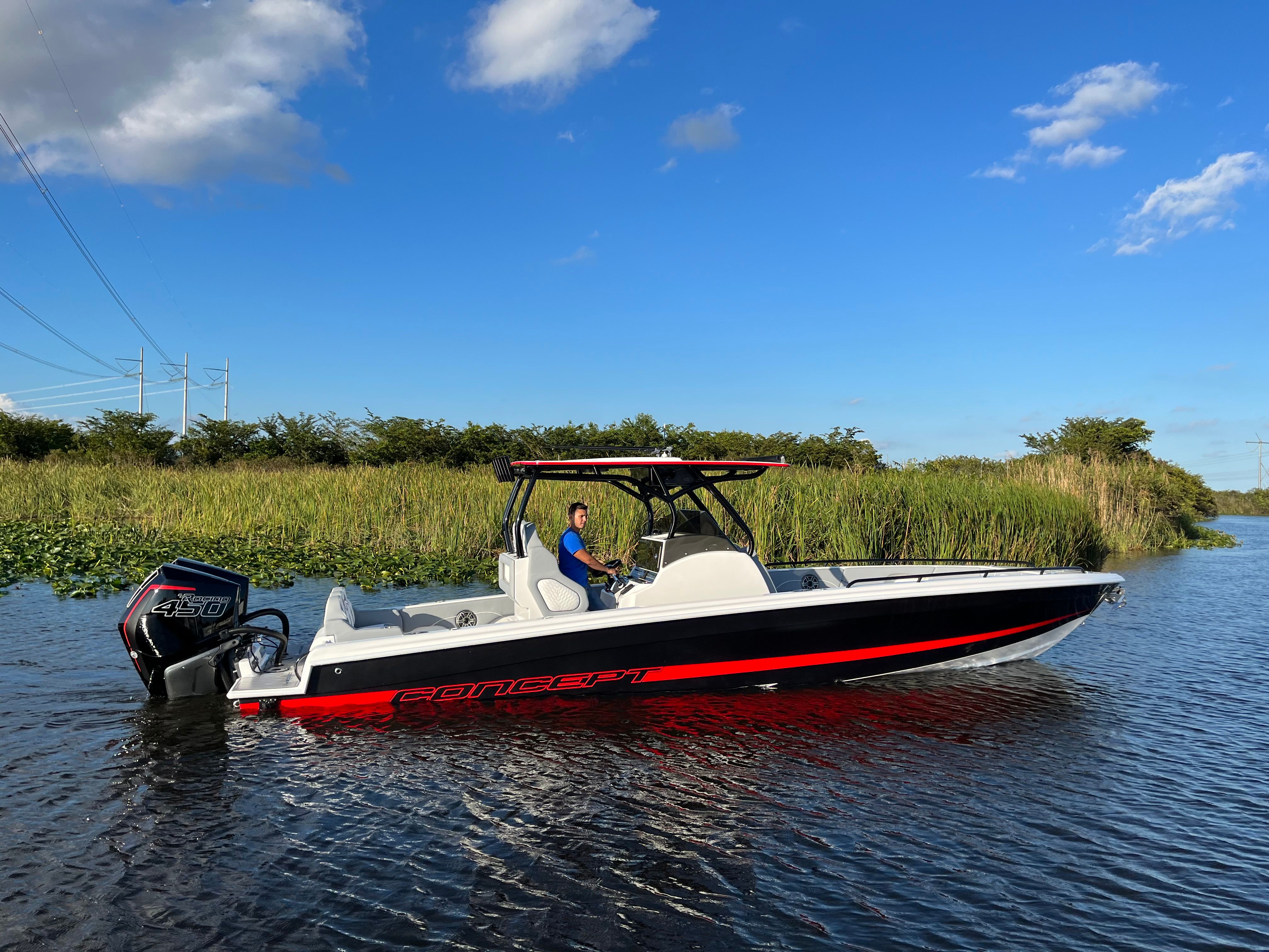 Concept 32' CC 2023 Concept 32' CC boat on a calm river under a clear blue sky.