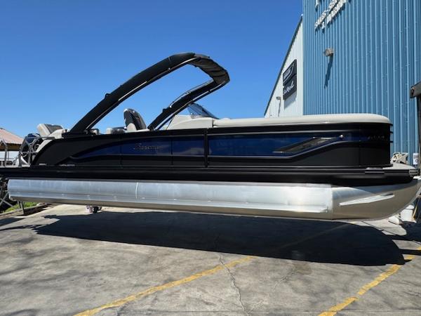 Barletta CORSA 25MA 2025 Barletta CORSA 25MA pontoon boat displayed outdoors near a blue building.