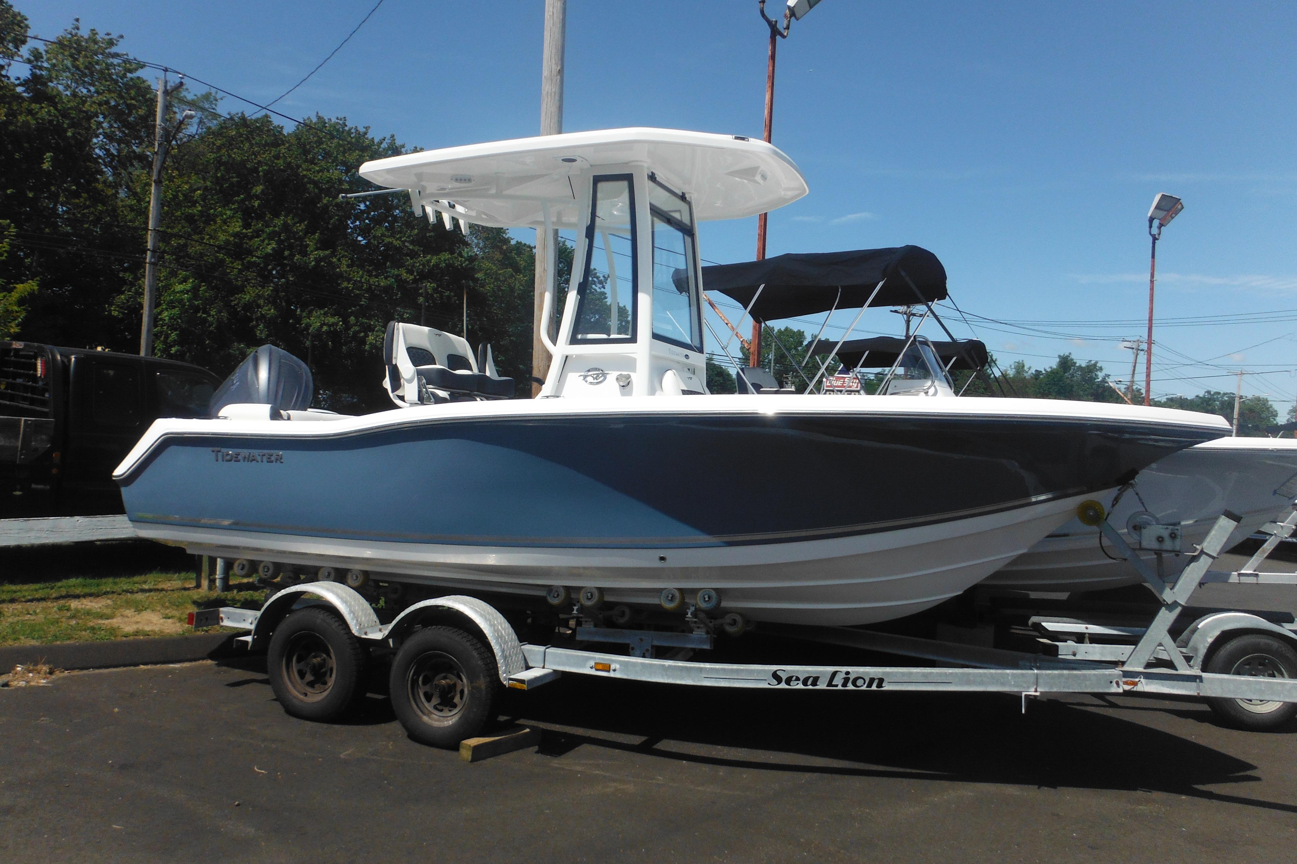 Tidewater 210 LXF 2026 Tidewater 210 LXF boat on trailer, parked outdoors under clear sky.