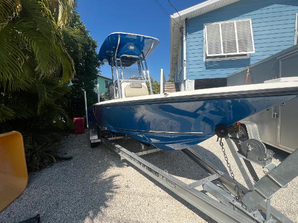 Key West 210 Bay Reef 2021 Key West 210 Bay Reef boat on trailer, parked beside a blue house.