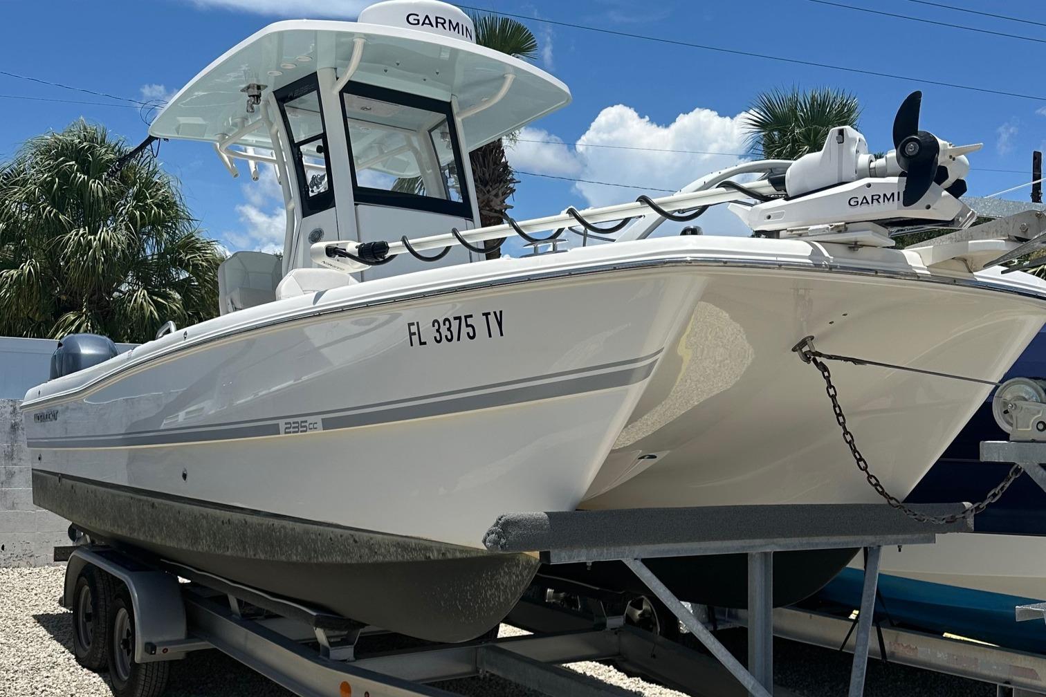 World Cat 235 CC 2024 World Cat 235 CC boat on trailer, featuring Garmin equipment, parked outdoors.